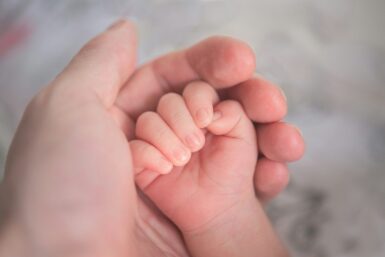 gros plan d'une main de bébé dans une main d'adulte